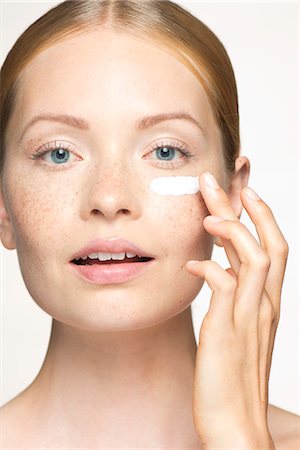 simsearch:632-07161489,k - Young woman applying moisturizer under eye Photographie de stock - Premium Libres de Droits, Code: 632-07494938