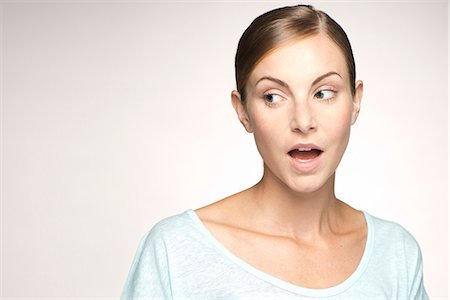 surprise expression women - Young woman looking away with mouth open in surprise, portrait Stock Photo - Premium Royalty-Free, Code: 632-07494958