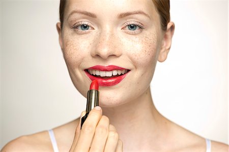 smiling lips - Young woman applying lipstick, portrait Foto de stock - Sin royalties Premium, Código: 632-07494976