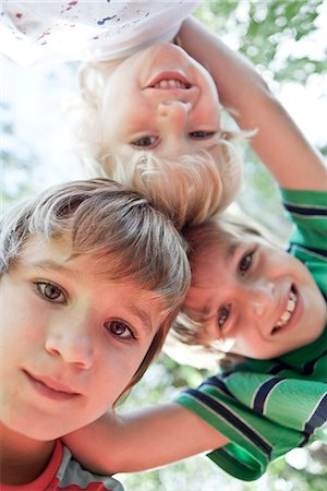 Boys huddling, smiling down at camera Stock Photo - Premium Royalty-Free, Code: 632-07494980