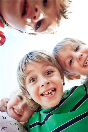 Boys huddling, smiling down at camera Stock Photo - Premium Royalty-Free, Code: 632-07494981