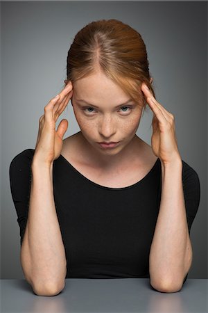 sadness - Young woman holding head, portrait Stock Photo - Premium Royalty-Free, Code: 632-07494999