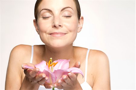 Young woman holding lily in cupped hands, eyes closed Foto de stock - Sin royalties Premium, Código: 632-07495013