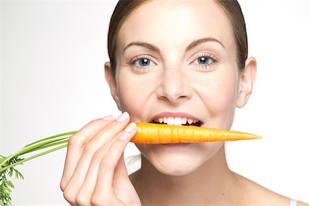 food people health - Young woman biting into carrot, portrait Stock Photo - Premium Royalty-Free, Code: 632-07495060