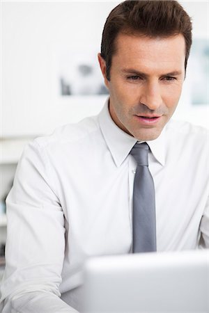 simsearch:632-07674665,k - Businessman using laptop working in office Stock Photo - Premium Royalty-Free, Code: 632-07539873