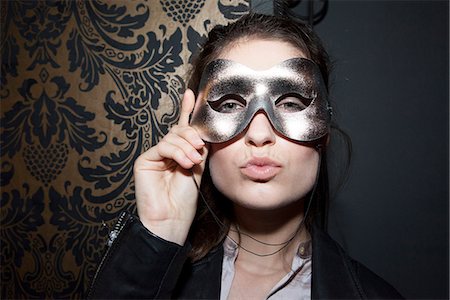 Woman wearing party mask, pursing lips, portrait Photographie de stock - Premium Libres de Droits, Code: 632-07539881