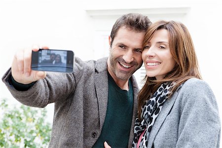 selfie photos - Couple taking self portrait with camera phone Stock Photo - Premium Royalty-Free, Code: 632-07539932