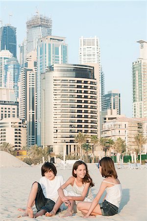 Siblings sitting together on beach, Dubai, United Arab Emirates Stock Photo - Premium Royalty-Free, Code: 632-07539956