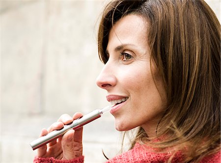 Woman smoking electronic cigarette, profile Foto de stock - Sin royalties Premium, Código: 632-07539962