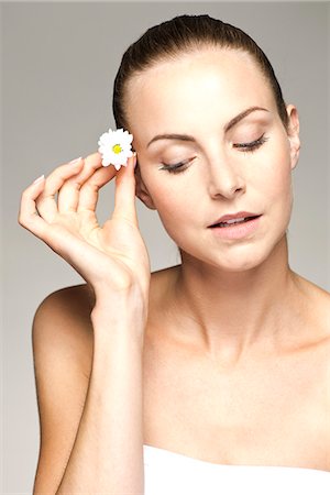 simsearch:632-07540029,k - Young woman placing flower in her hair Stock Photo - Premium Royalty-Free, Code: 632-07539985