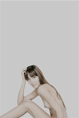desnudo - Nude young woman sitting with knees raised, holding head, smiling at camera Foto de stock - Sin royalties Premium, Código: 632-07540052