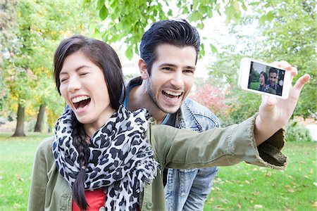 smiling friends taking picture together - Couple taking self portrait with smartphone Stock Photo - Premium Royalty-Free, Code: 632-07674444