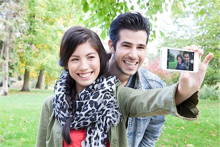 smiling friends taking picture together - Couple taking self-portrait Stock Photo - Premium Royalty-Free, Code: 632-07674445