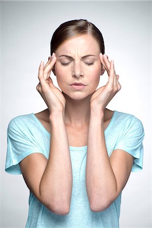 sien - Young woman with headache holding head Foto de stock - Sin royalties Premium, Código: 632-07674440