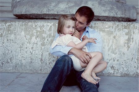 Father holding young daughter on his lap Stock Photo - Premium Royalty-Free, Code: 632-07674648