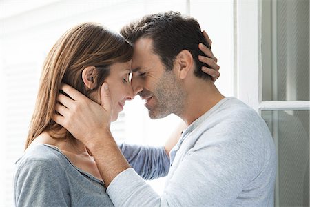 romance couple - Couple cuddling by open window Foto de stock - Sin royalties Premium, Código: 632-07674658