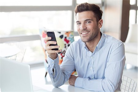 Man with look of satisfaction holding smartphone Stock Photo - Premium Royalty-Free, Code: 632-07674673