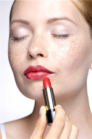 pintalabios - Young woman putting on lipstick Foto de stock - Sin royalties Premium, Código: 632-07674754