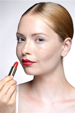 simsearch:659-06183745,k - Young woman putting on lipstick Stock Photo - Premium Royalty-Free, Code: 632-07674756