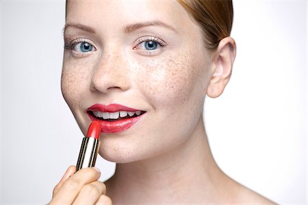 Young woman putting on lipstick Foto de stock - Sin royalties Premium, Código: 632-07674751