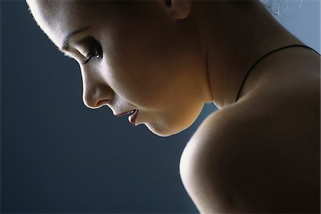 regret - Young woman looking down, profile, close-up Stock Photo - Premium Royalty-Free, Code: 632-07674767