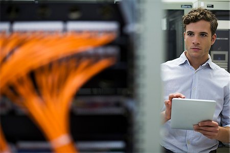 Computer technician using digital tablet performing maintenance check of mainframe equipment Stock Photo - Premium Royalty-Free, Code: 632-07809290