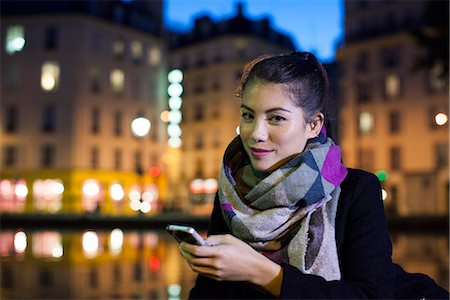 smartphone night - Young woman outdoors using smartphone, portrait Stock Photo - Premium Royalty-Free, Code: 632-07809410