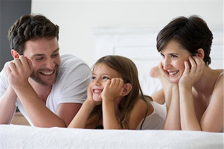 simsearch:632-08129876,k - Parents and daughter lying on bed together, portrait Stock Photo - Premium Royalty-Free, Code: 632-07809461