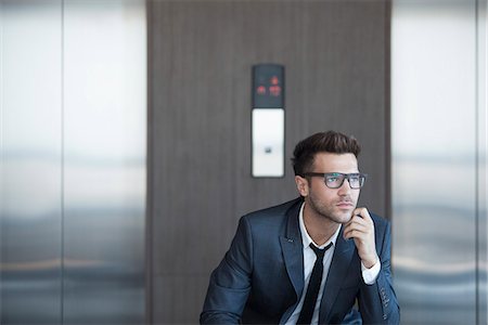 simsearch:632-06317985,k - Businessman sitting in lobby, looking away in thought Fotografie stock - Premium Royalty-Free, Codice: 632-07809514