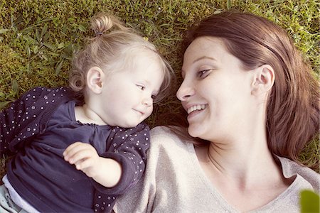 smiling baby pictures - Mother and baby girl lying on grass, smiling at each other Stock Photo - Premium Royalty-Free, Code: 632-07849468