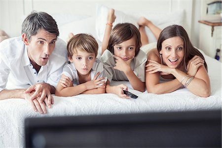 Family watching TV on bed, portrait Stock Photo - Premium Royalty-Free, Code: 632-08001766