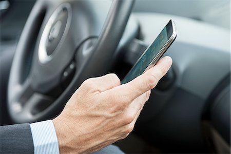 person holding hand as phone - Using smartphone while driving Stock Photo - Premium Royalty-Free, Code: 632-08001881