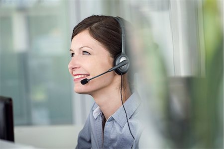 rezeptionist - Receptionist wearing headset, smiling cheerfully Photographie de stock - Premium Libres de Droits, Code: 632-08129779