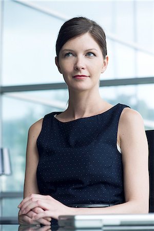 simsearch:632-08130314,k - Businesswoman sitting at desk, looking away in thought, portrait Stock Photo - Premium Royalty-Free, Code: 632-08129836