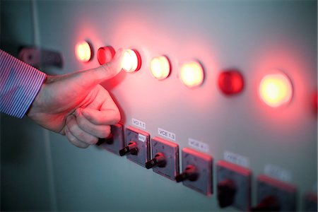 Worker pressing illuminated buttons on industrial control panel Stock Photo - Premium Royalty-Free, Code: 632-08129941