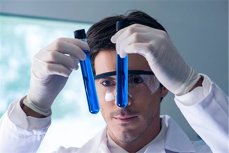 Researcher scrutinizing test tubes containing blue liquid in lab Photographie de stock - Premium Libres de Droits, Code: 632-08130048