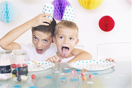 sacando la lengua - Young brothers making faces during a birthday party Foto de stock - Sin royalties Premium, Código: 632-08130066