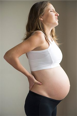 simsearch:632-08227812,k - Pregnant woman massaging lower back Stock Photo - Premium Royalty-Free, Code: 632-08227406