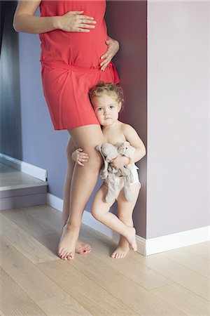 Little girl clinging to her pregnant mother's leg with worried expression on face Photographie de stock - Premium Libres de Droits, Code: 632-08227480