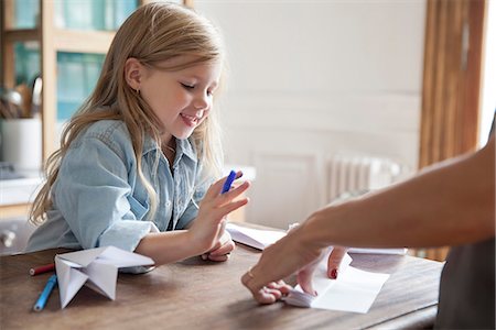 parents talking to children at home - Little girl learning how to make paper airplane Stock Photo - Premium Royalty-Free, Code: 632-08227555