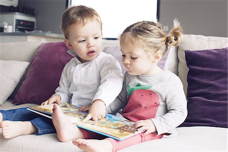 sitting full body - Young siblings looking at book together Stock Photo - Premium Royalty-Free, Code: 632-08227560