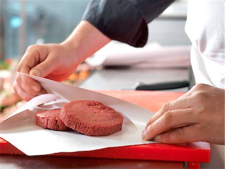 protéine - Butcher wrapping beef patties in wax paper, cropped Photographie de stock - Premium Libres de Droits, Code: 632-08227686