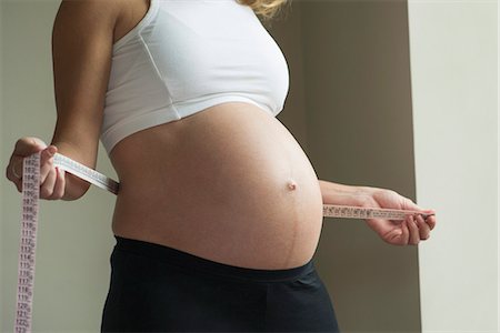 simsearch:632-08227760,k - Pregnant woman measuring waistline Stock Photo - Premium Royalty-Free, Code: 632-08227764