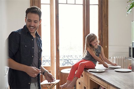 Girl helping father set table for family meal Stock Photo - Premium Royalty-Free, Code: 632-08227842