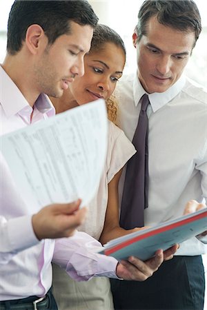 simsearch:632-03779792,k - Businessman discussing documents with colleagues Stock Photo - Premium Royalty-Free, Code: 632-08227854