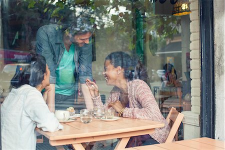 simsearch:632-08331381,k - Waiter talking to customers in coffee shop Foto de stock - Sin royalties Premium, Código: 632-08331403