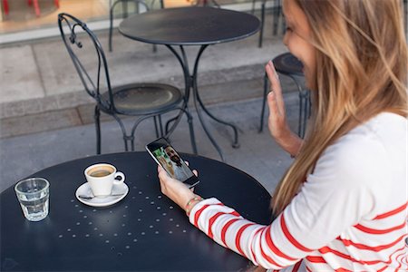 Young woman using smartphone to video chat in cafe Foto de stock - Sin royalties Premium, Código: 632-08331440