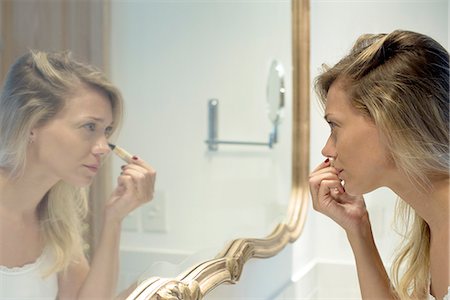 pinceau de maquillage - Woman applying cosmetics Photographie de stock - Premium Libres de Droits, Code: 632-08331543