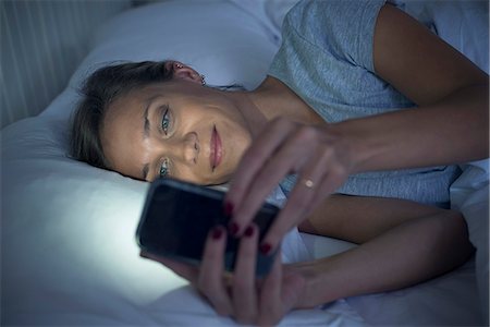 people looking at smartphone home not children - Woman in bed using smartphone Stock Photo - Premium Royalty-Free, Code: 632-08331563