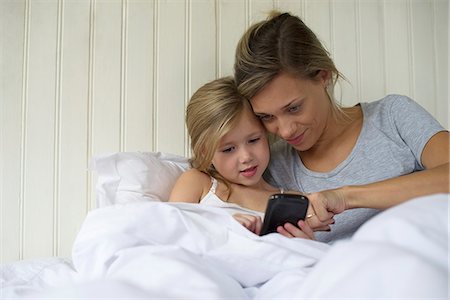 simsearch:614-08875430,k - Mother and daughter using smartphone together Fotografie stock - Premium Royalty-Free, Codice: 632-08331602